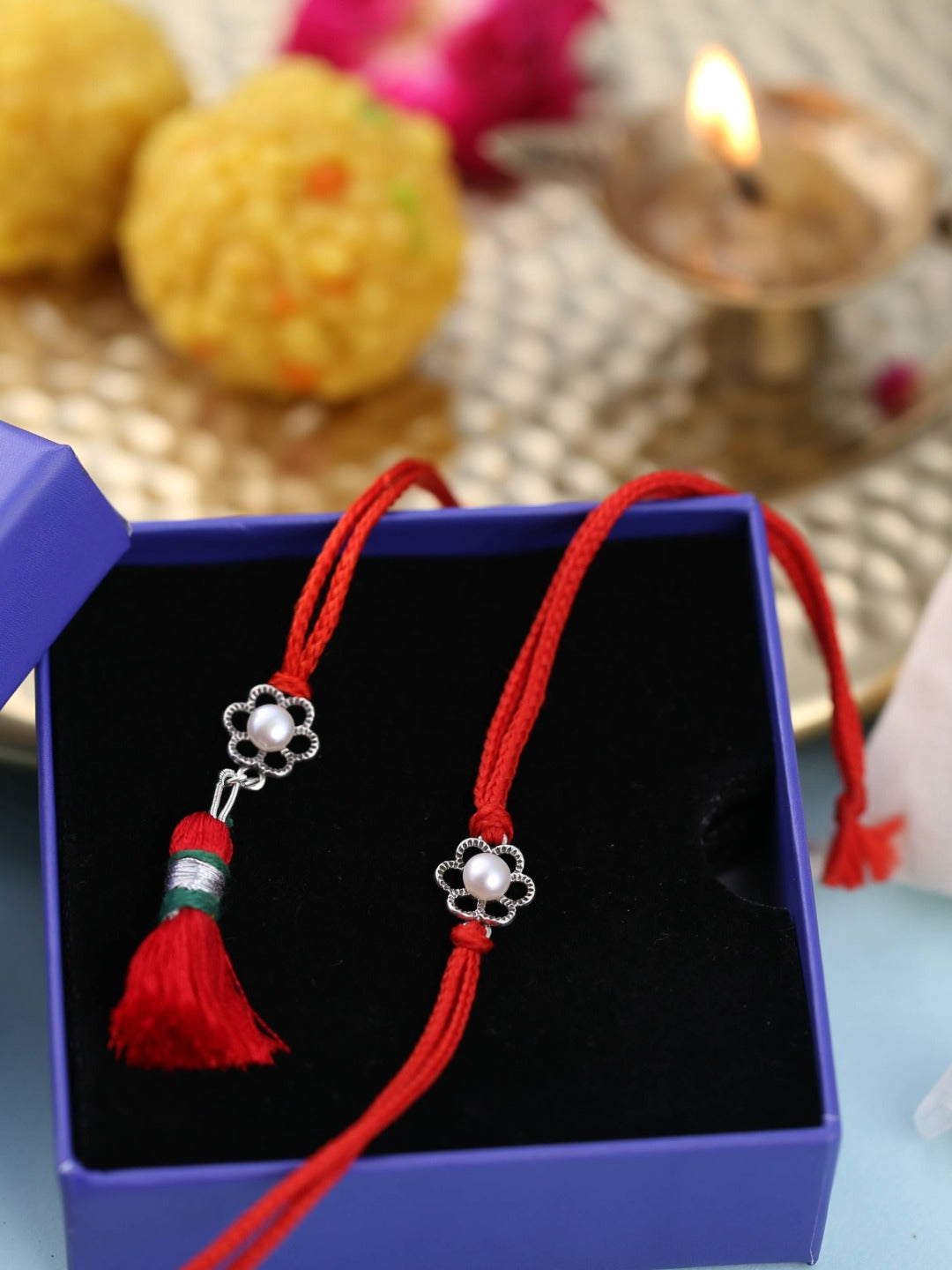 Floral pearl rakhi and lumba presented in an open gift box