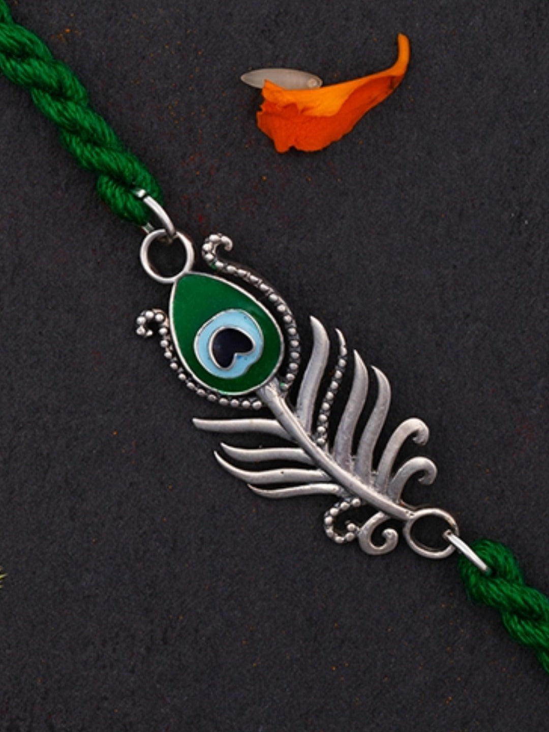 Close-up of the enamelled peacock feather charm in green and blue
